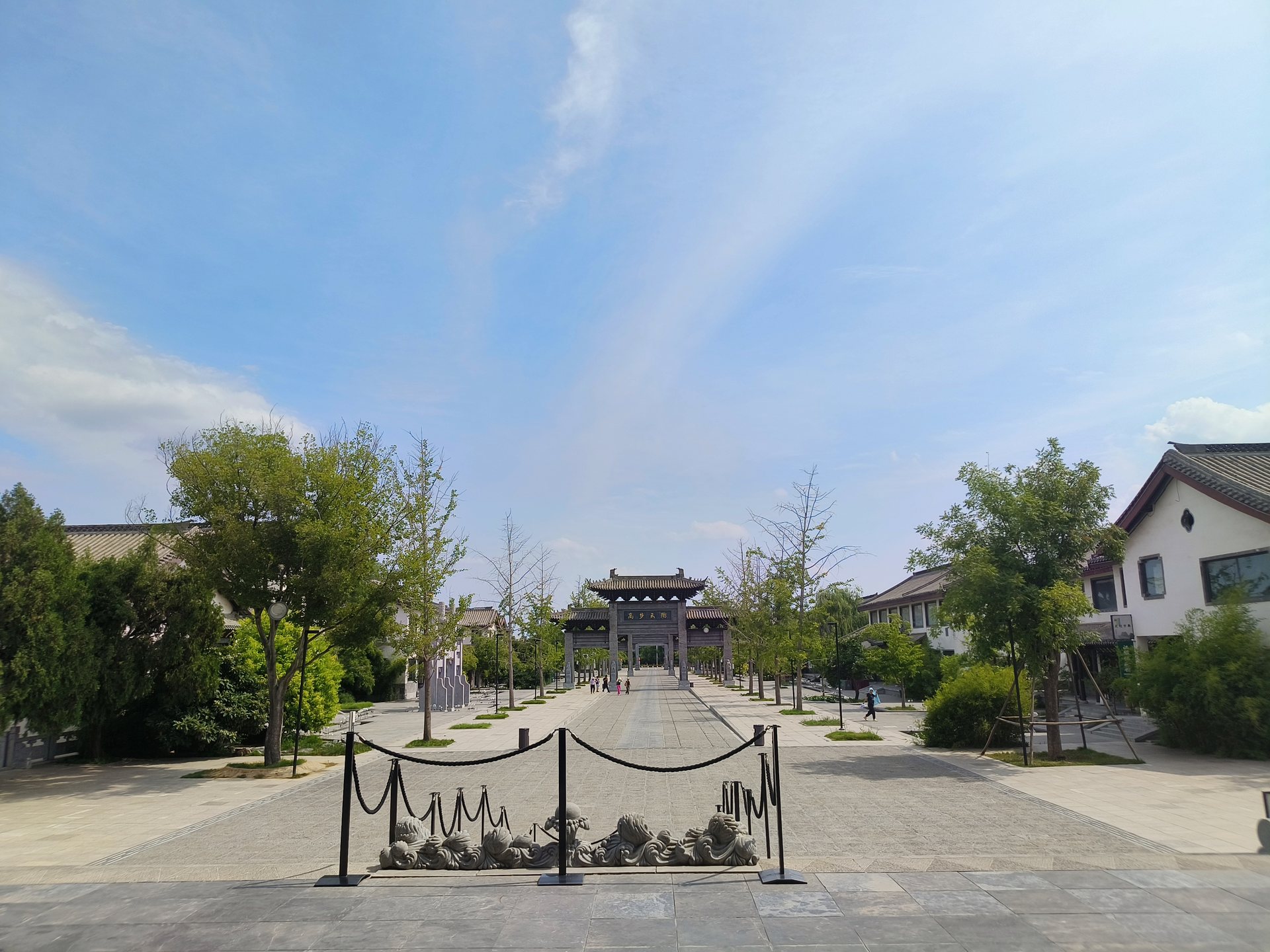 水墨园的园路在绿树与天空之间向前延伸